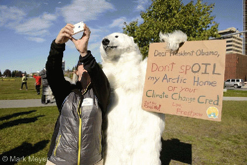 Peggy Wilcox of Anchorage takes a selfie with Frostpaw the polar bear at the rally.