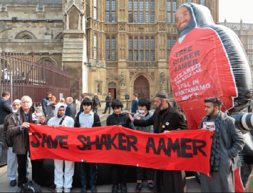 Shaker Aamer's sons with the giant inflatable figure of Shaker Aamer outside Parliament