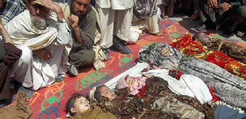 Afghan villagers sit near the bodies of children killed by U.S. drone