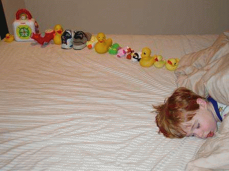 Quinn, an autistic boy, and the line of toys he made before falling asleep. Repeatedly stacking or lining up objects is a behavior commonly associated with autism. Credit: Wikipedia.