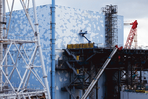 A worker on the outside wall of the Reactor 2 building at the Fukushima Daiichi Nuclear Power Station last month.