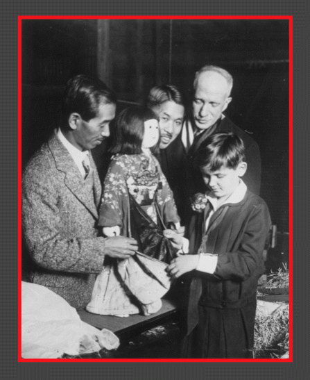 Rev. Sydney Gulick meets Miss Nagoya in Chicago along with Ryukichi Sekiya and the Japanese Consul, Tamara Tajiro. A local Girl Scout. Miss Elizabeth Getch. inspects the kimono, Chicago, December 15, 1927.