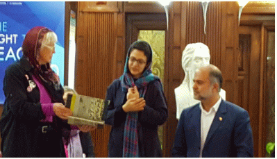 Delegation member Barbara Briggs-Letson presenting book with names of 290 passengers and crew of Iran Air flight 655 to Director of the Tehran Peace Museum