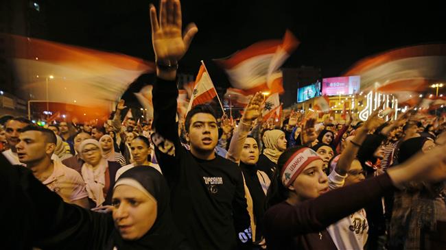 Lebanese protesters wave flags and shout slogans during an anti-government demonstration at al-Nour Square in the northern port city of Tripoli on November 2, 2019.