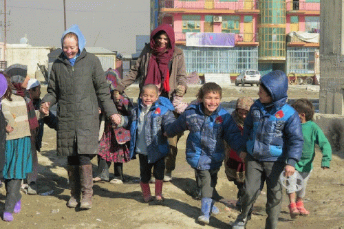 Kathy Kelly and Maya Evans walk with children at the Chamin-E-Babrak refugee camp in Kabul, Afghanistan, January 2014., From Uploaded