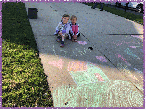 Mila and Zoe pose with their artwork