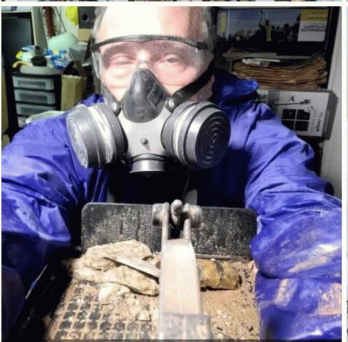 Me working at my lapidary ' Diamond wet saw. I've since added a hat to my gear. Some stones throw sharp chips.